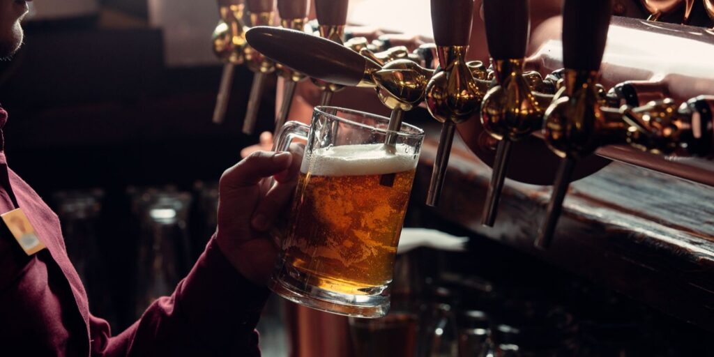 Bartender filling beer mug from beer tap