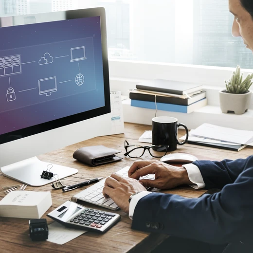 Businessman working at a desktop computer displaying finance data and information